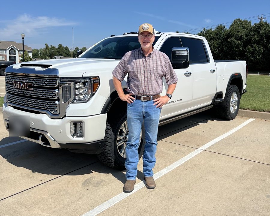 Greg McKinney of Mineola, Texas, standing beside his white pickup