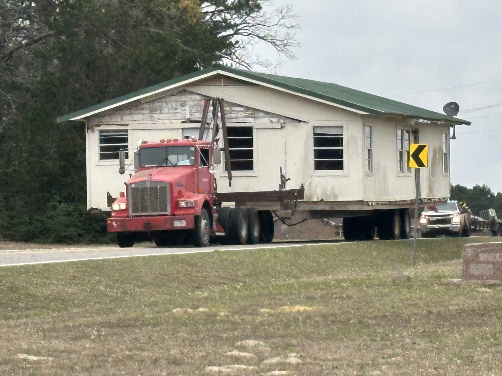 Frame house being moved down a country road near Pine Mills, Texas