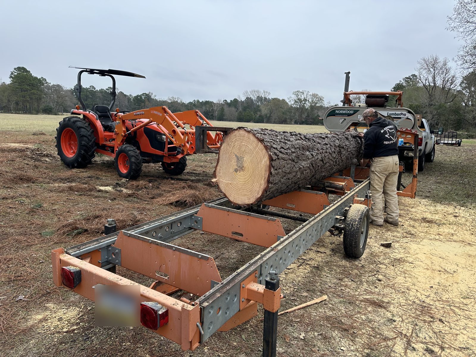 Portable sawmill cutting a pine log into lumber in East Texas