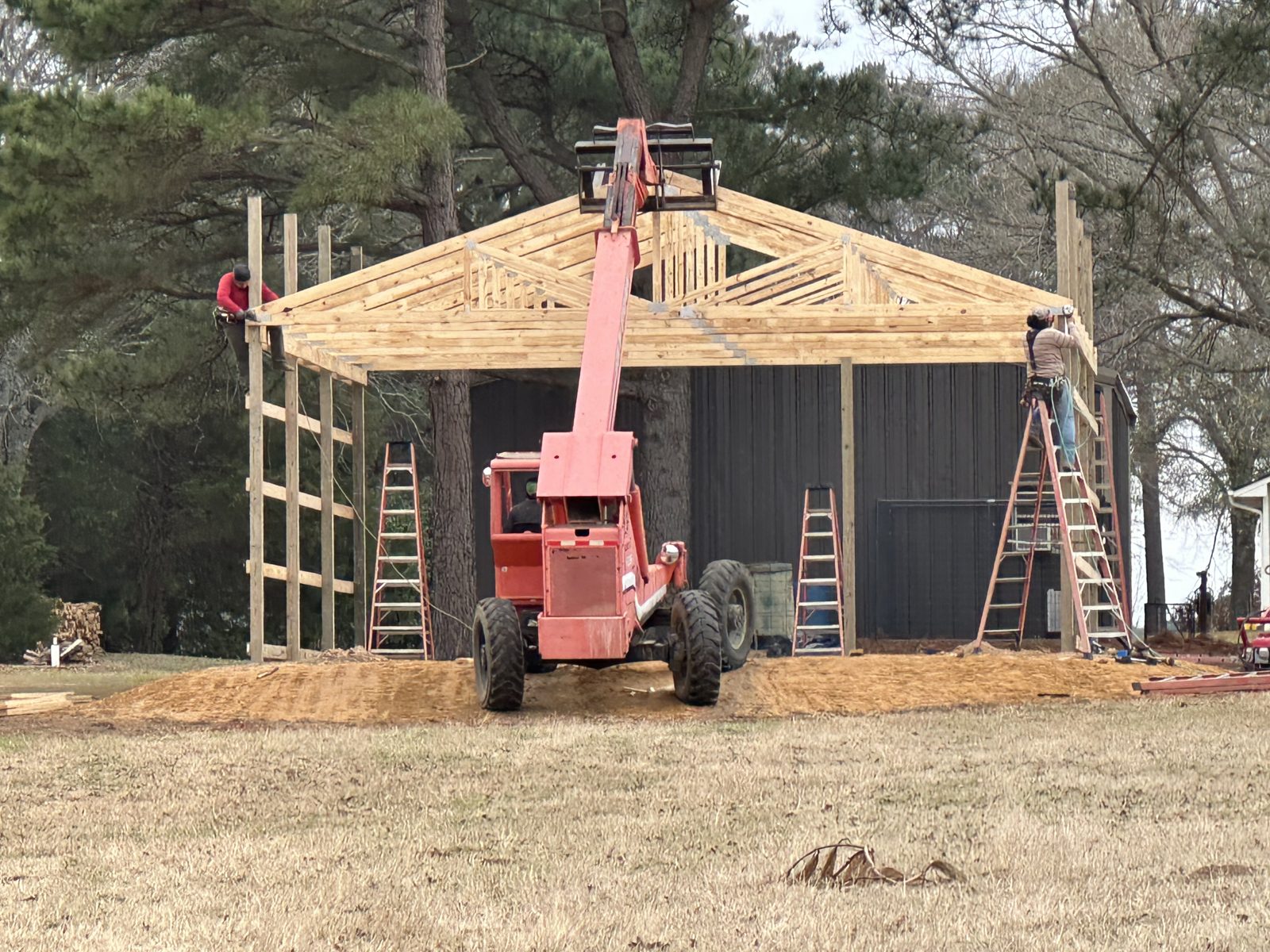 Crew raising trusses on a new pole barn in East Texas