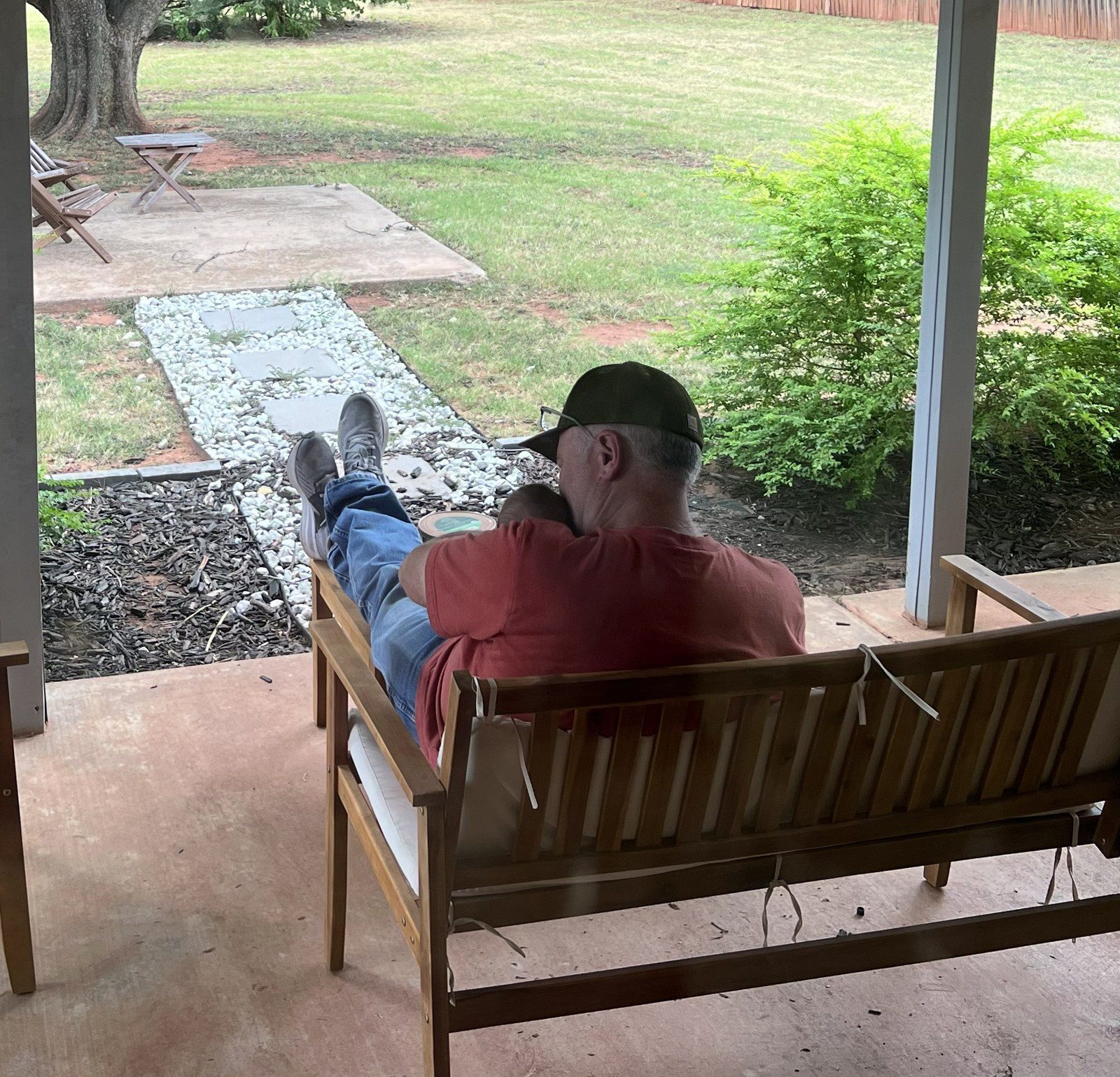Greg McKinney relaxing on the porch with a baby, East Texas