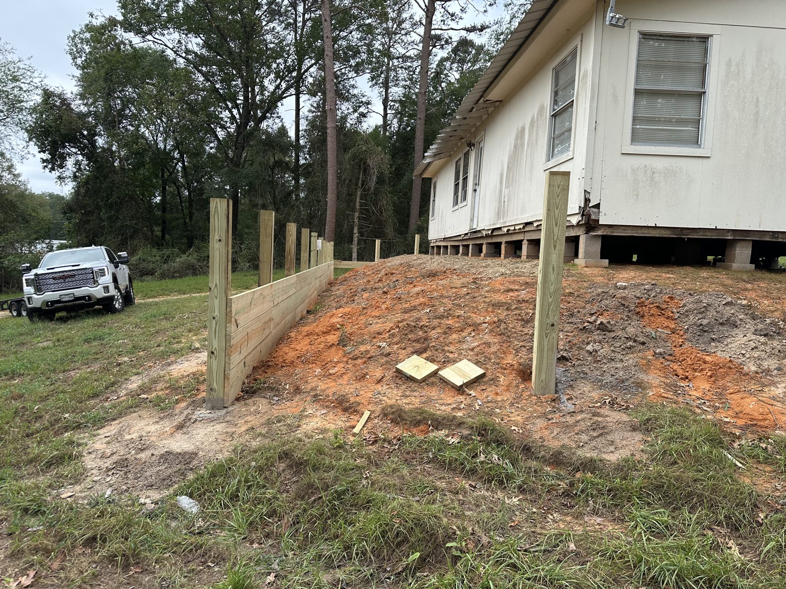 Retaining wall along the side of a frame house in Pine Mills, Texas