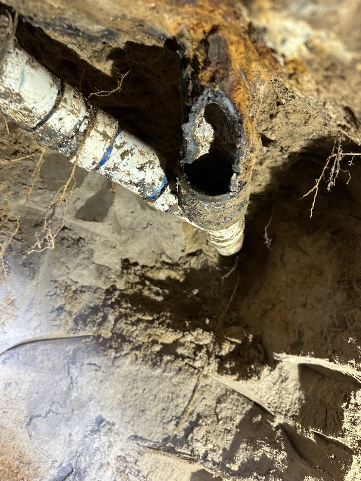 Rusted cast iron drain pipe under a house in East Texas