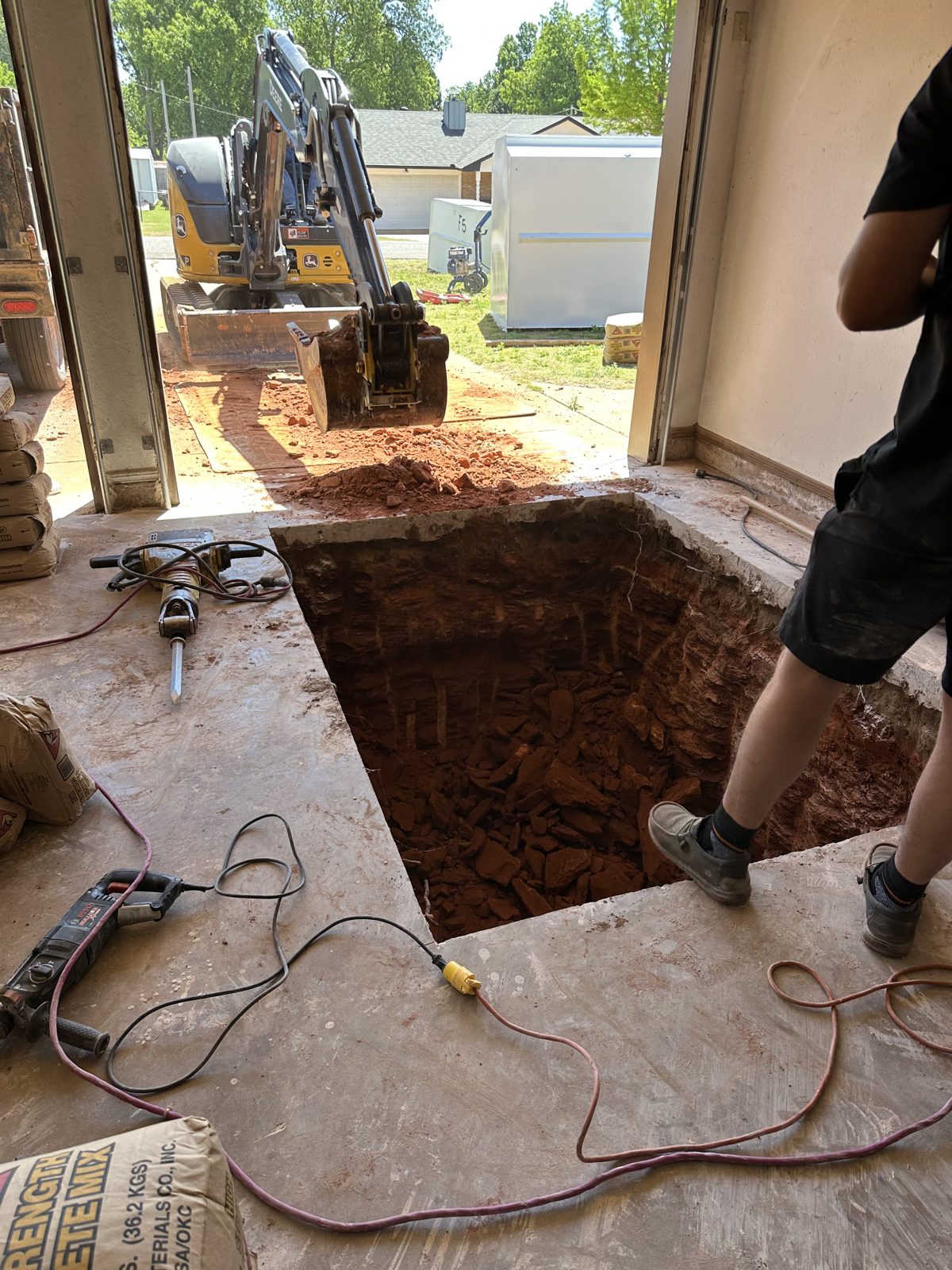 Storm shelter pit dug through a garage slab in East Texas